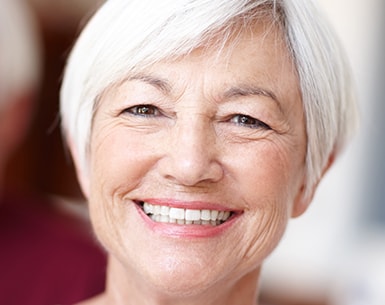 Older woman with short white hair smiling