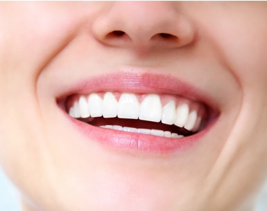 Smiling woman's mouth with pink lips and white teeth